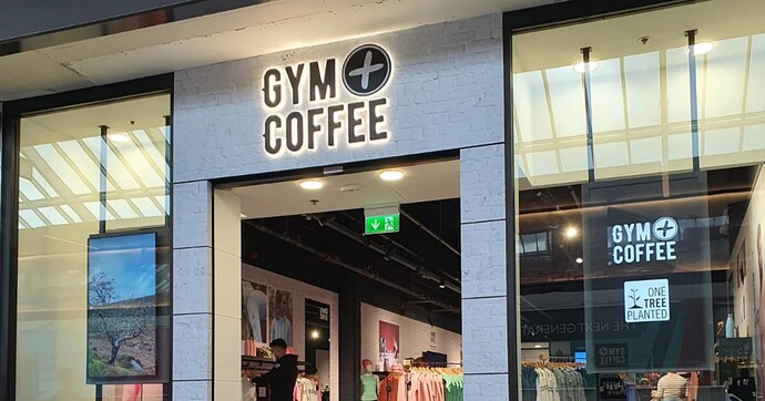 一家健身服零售商的店面，入口两侧有数字屏幕。